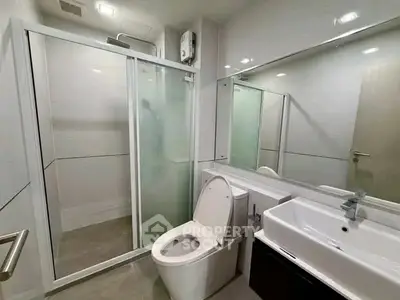 Modern bathroom with glass shower and sleek fixtures in a contemporary apartment.