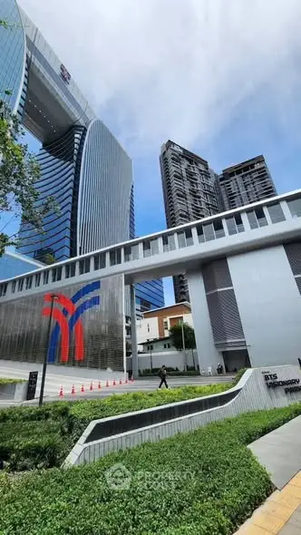 Modern high-rise buildings with sleek architecture and lush greenery in urban setting.