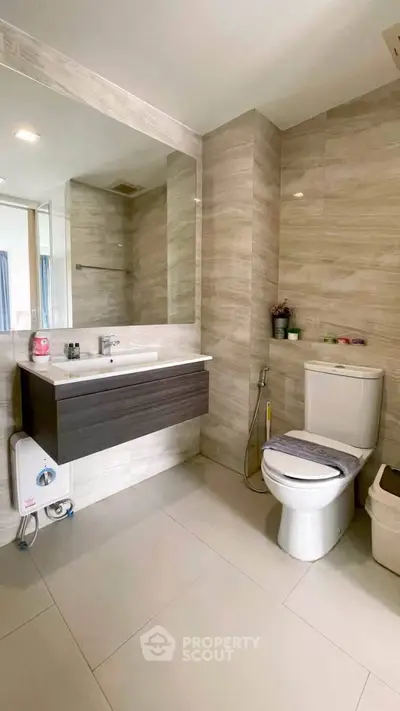 Modern bathroom with sleek fixtures and elegant tile design, featuring a spacious vanity and contemporary toilet.