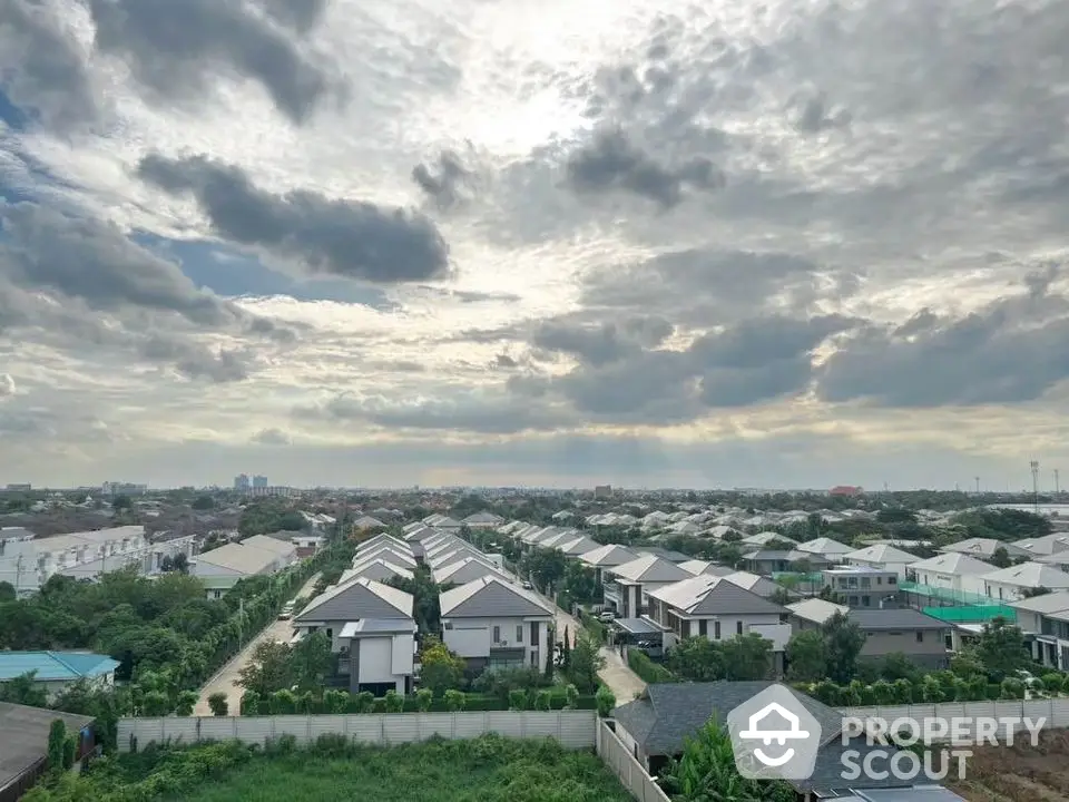 Stunning aerial view of modern suburban neighborhood with lush greenery and dramatic sky.