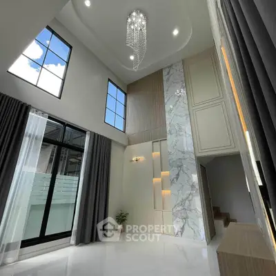 Luxurious high-ceiling living room with elegant chandelier and modern design