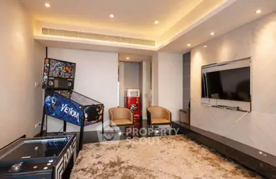 Luxurious living room with entertainment area featuring pinball machine and modern decor.