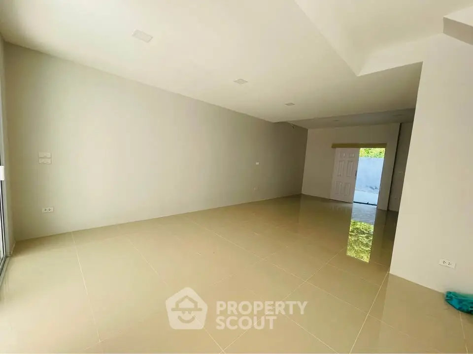 Spacious empty room with tiled flooring and natural light, ideal for customization.