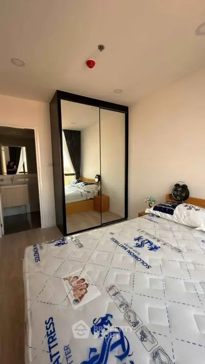 Modern bedroom with mirrored wardrobe and stylish decor in a cozy apartment.