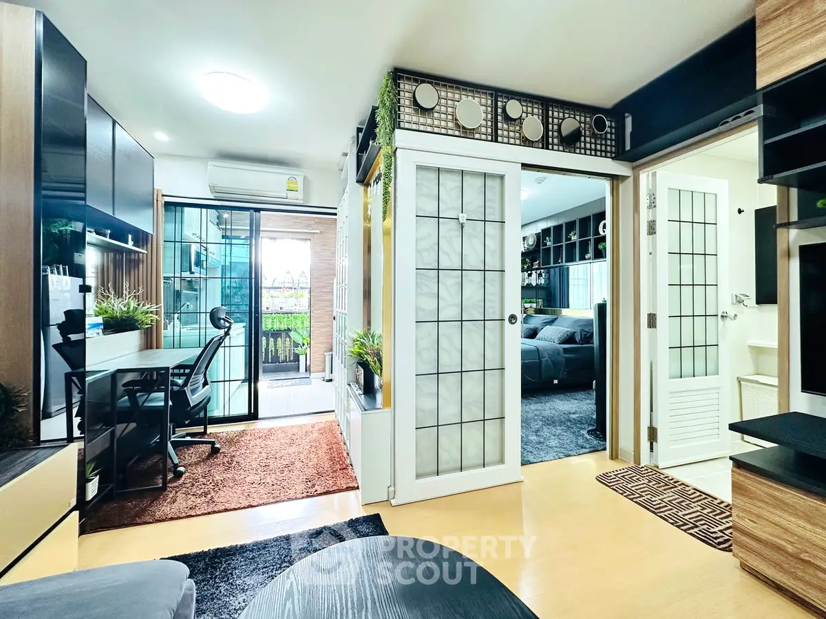 Modern living room with sliding doors and balcony view, featuring stylish decor and ample natural light.