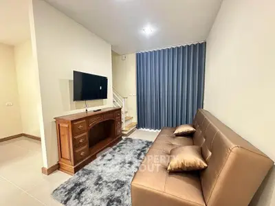 Cozy living room with modern sofa, TV, and elegant decor in a stylish apartment.