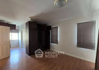 Spacious bedroom with wooden flooring and built-in wardrobe