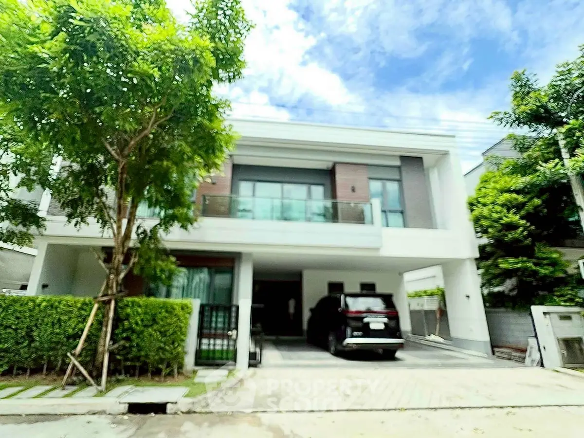 Modern two-story house with lush greenery and spacious driveway