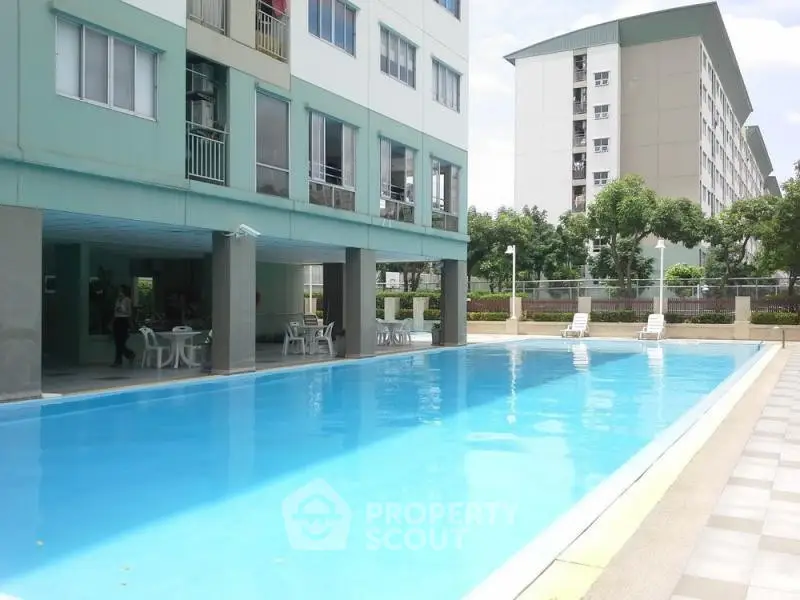 Modern residential building with inviting outdoor pool and lounging area.