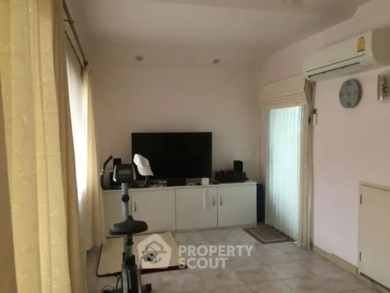 Cozy living room with exercise bike and modern entertainment setup