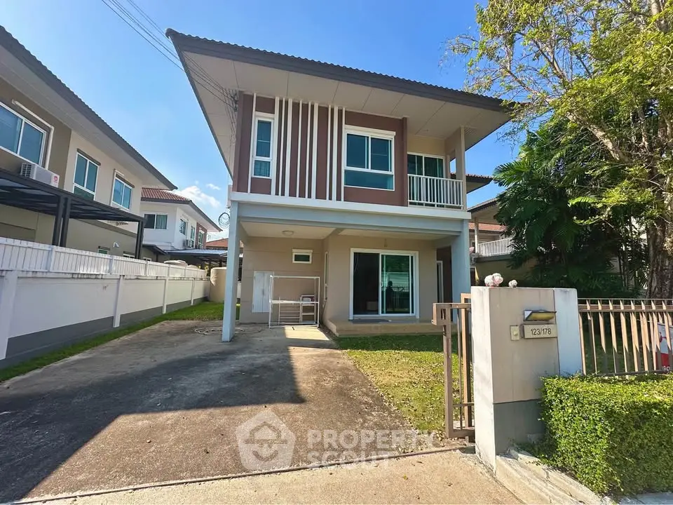 Modern two-story house with driveway and lush greenery in a serene neighborhood.