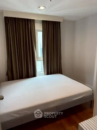Cozy bedroom with natural light and elegant curtains in modern apartment.