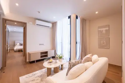 Elegant living room with modern decor and natural light, featuring a cozy sofa and stylish wooden flooring.