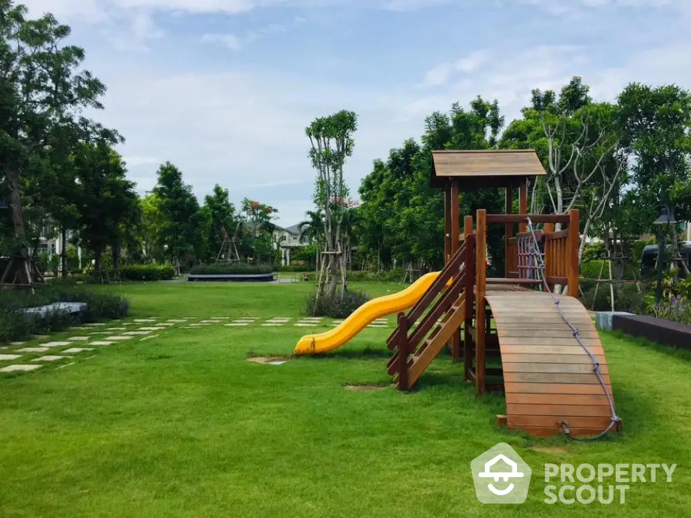 Lush green garden space with a vibrant children's play area featuring a slide and wooden playset, ideal for family-friendly living.