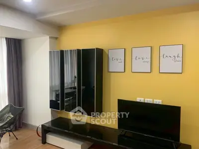 Modern living room with stylish wall decor and sleek black furniture, perfect for contemporary living.