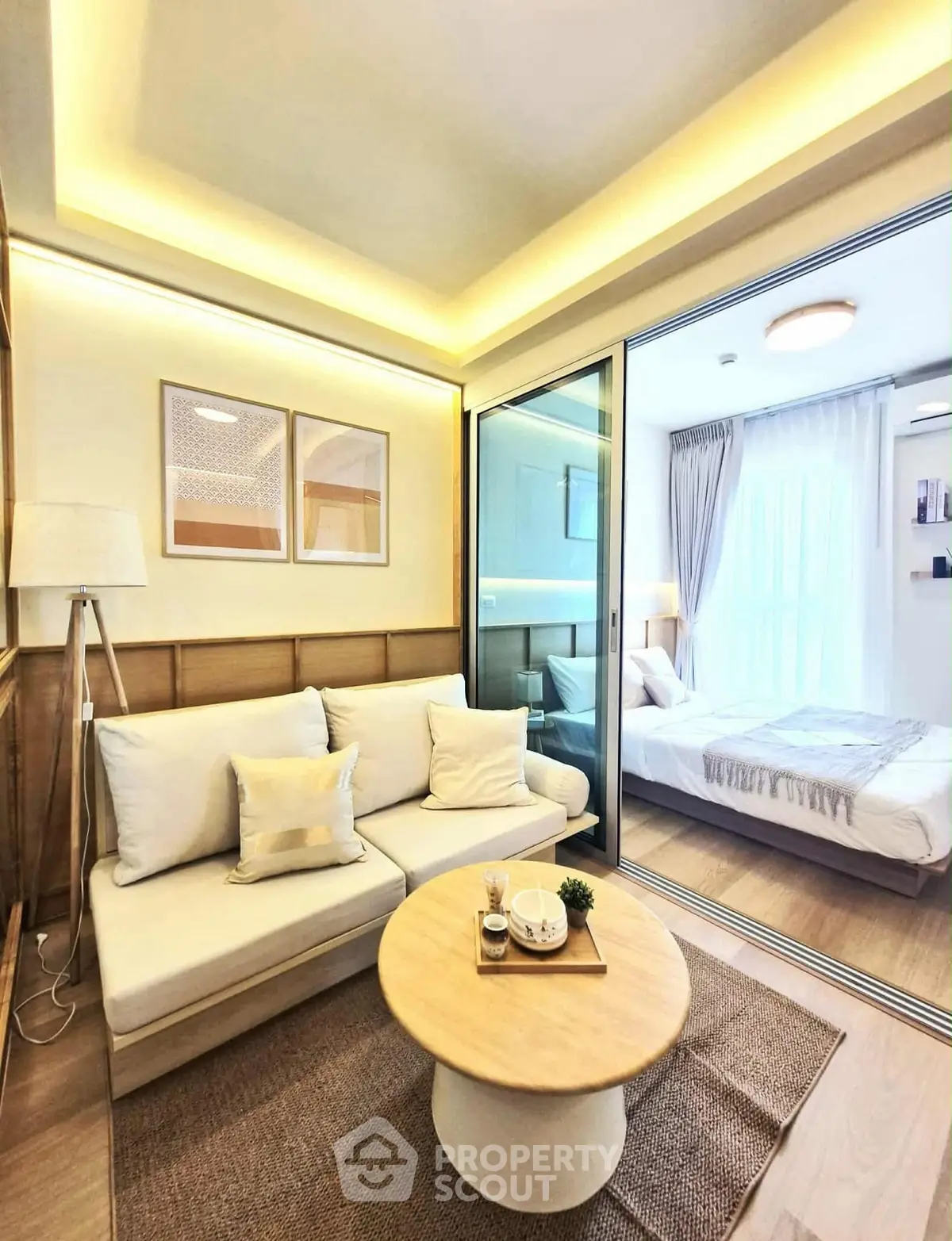 Modern living room with cozy sofa and stylish decor adjacent to bright bedroom.