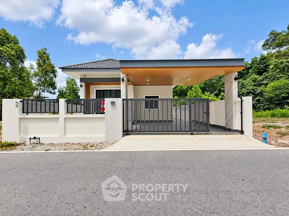 Modern single-story house with sleek design and spacious driveway in a serene neighborhood.