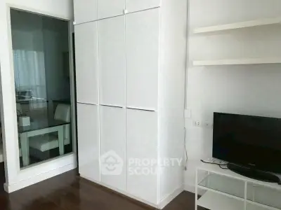Modern living room with sleek white furniture and built-in storage