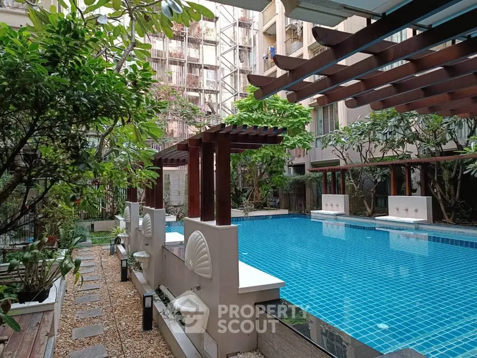 Luxurious residential pool area with lush greenery and elegant design elements.