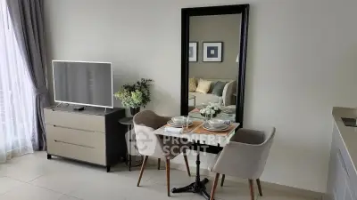 Modern living room with dining area, sleek TV stand, and elegant decor in a cozy apartment.
