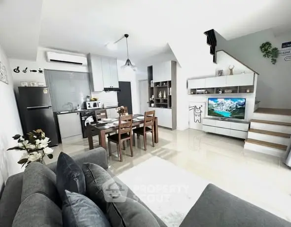 Modern open-plan living room with sleek kitchen and stylish decor