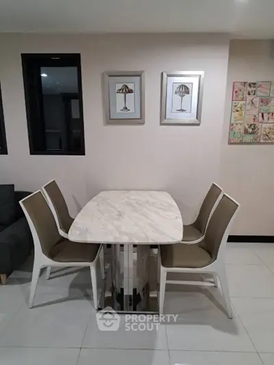 Modern dining area with elegant marble table and stylish chairs in a contemporary apartment.