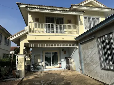 Charming two-story house with balcony and spacious driveway in a serene neighborhood.