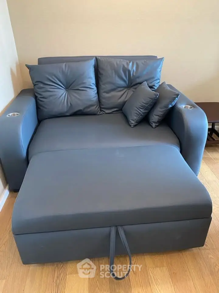 Modern gray sofa bed with plush cushions in a cozy living room setting.