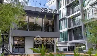 Modern apartment building exterior with lush greenery and stylish architecture.