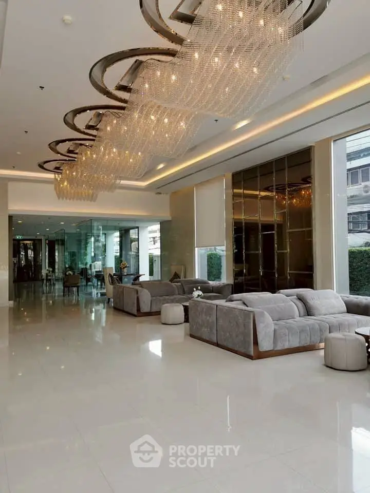 Luxurious modern living room with elegant chandeliers and plush seating in a high-end property.