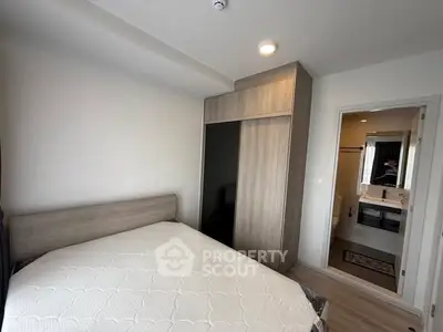 Modern bedroom with wooden wardrobe and ensuite bathroom in a stylish apartment.