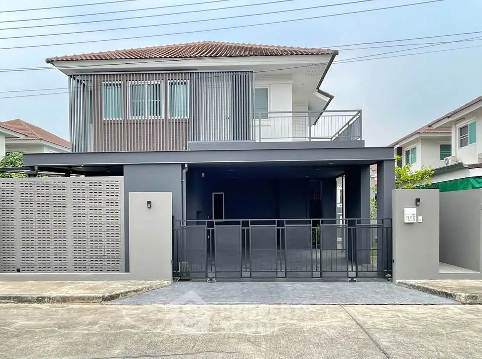 Modern two-story house with sleek design and spacious driveway in a suburban neighborhood.
