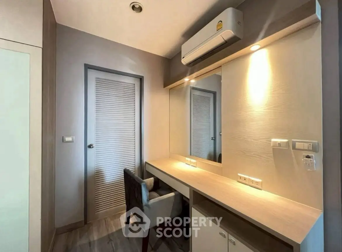 Modern study room with sleek desk, chair, and air conditioning in a stylish apartment.