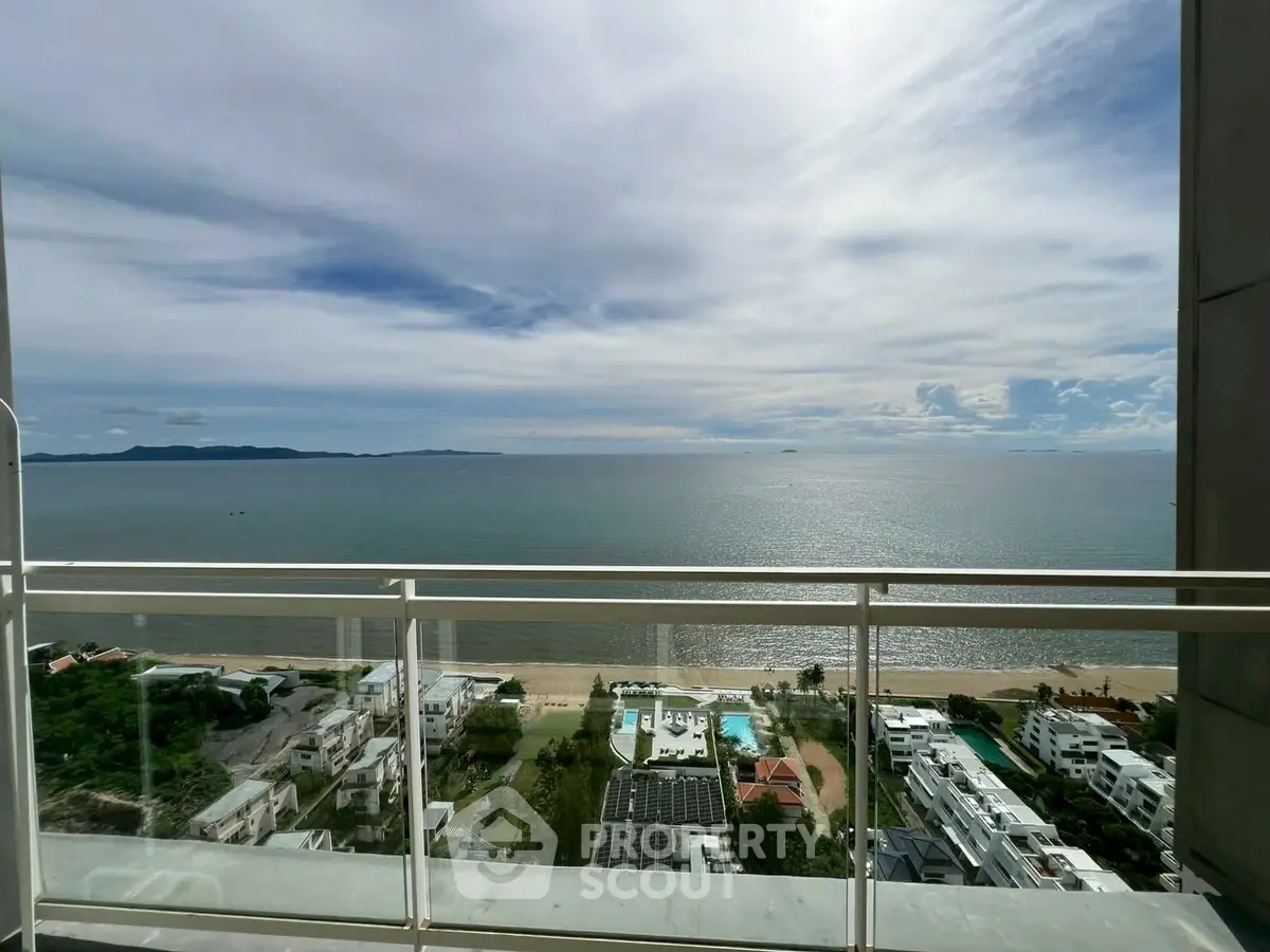 Stunning ocean view from high-rise balcony overlooking serene coastline and modern residences.