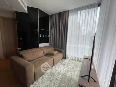 Modern living room with plush sofa and large window, featuring sleek decor and natural light.
