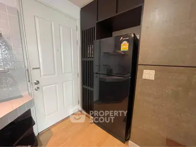 Modern kitchen corner with sleek black fridge and stylish cabinetry
