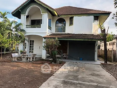 Charming two-story house with a spacious driveway and lush garden, perfect for family living.