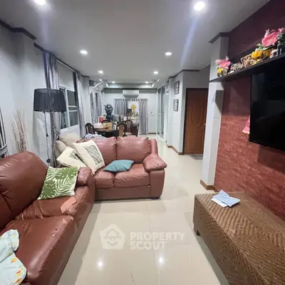 Spacious living room with leather sofas and modern decor, perfect for family gatherings.