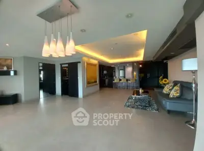 Spacious modern living room with stylish lighting and open kitchen layout