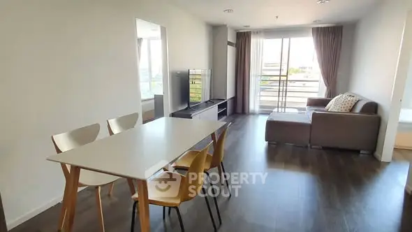 Spacious modern living room with dining area and balcony view
