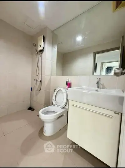 Modern bathroom with sleek fixtures and large mirror in a contemporary apartment.