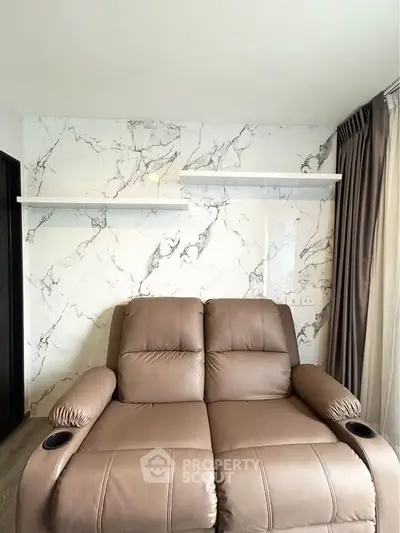 Luxurious living room with elegant marble accent wall and plush leather seating, perfect for relaxation.