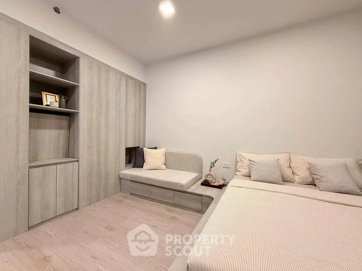 Modern bedroom with built-in storage and cozy seating area, perfect for relaxation and comfort.