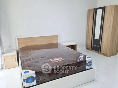 Modern bedroom with new mattress and stylish wardrobe in a bright apartment