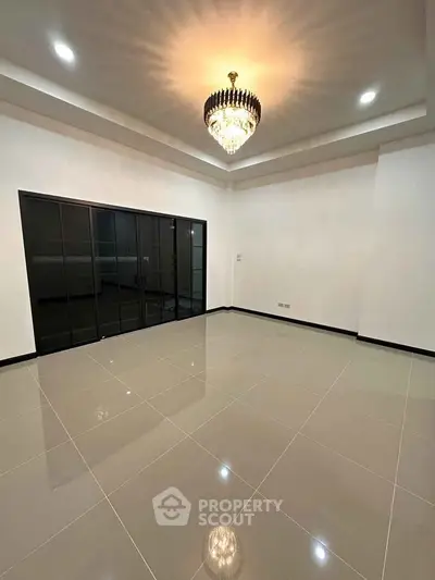 Spacious modern living room with elegant chandelier and glossy tiled floor