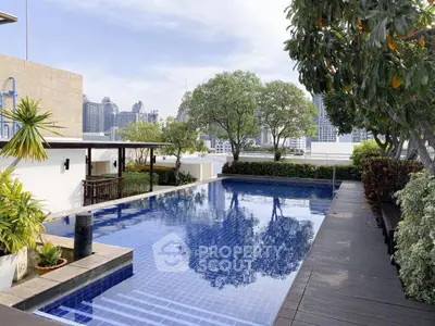 Luxurious rooftop pool with stunning city skyline views and lush greenery.