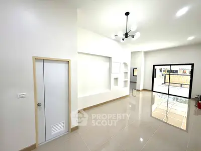 Spacious modern living room with sleek tile flooring and large windows for natural light.