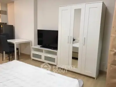 Modern bedroom with sleek white wardrobe and TV unit, ideal for urban living.