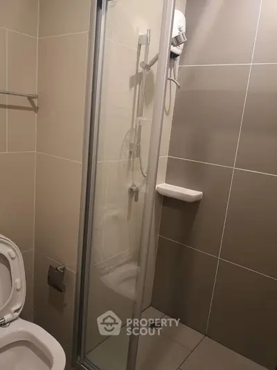 Modern bathroom with sleek shower and neutral tiles, perfect for a contemporary home.