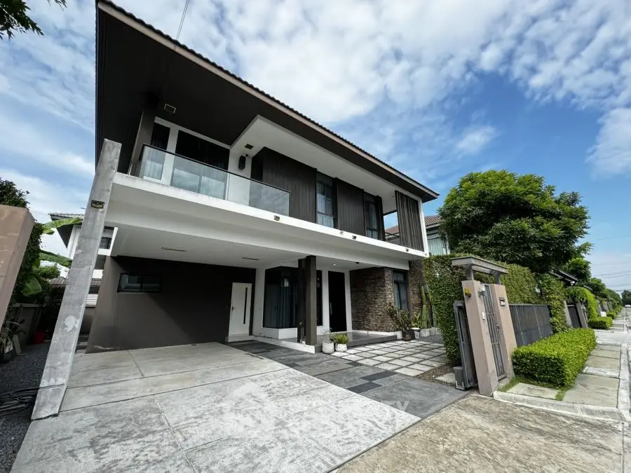 Modern two-story house with spacious driveway and lush greenery